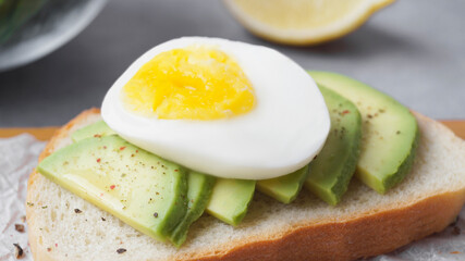 Delicious sandwich with boiled egg and pieces of avocado on table, closeup