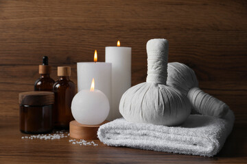Fototapeta na wymiar Beautiful spa composition with different care products and burning candles on wooden table