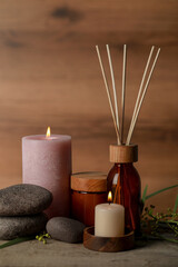 Beautiful spa composition with different care products and burning candles on wooden table