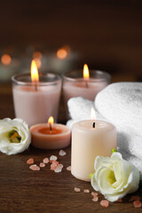 Fototapeta na wymiar Beautiful spa composition with burning candles and flowers on wooden table