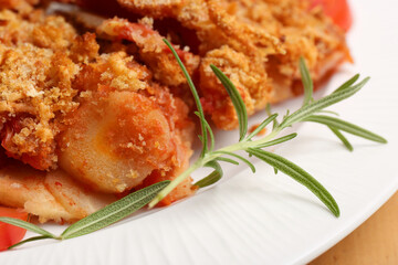 Tasty fried parsnips with rosemary on white plate, closeup