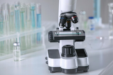 Modern medical microscope on white table in laboratory, closeup. Space for text