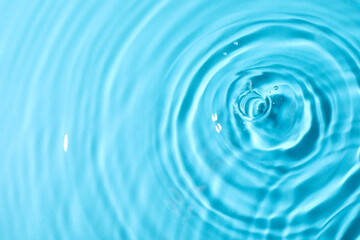 Naklejka na ściany i meble Closeup view of water with rippled surface on light blue background