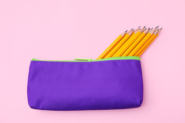 Many sharp pencils in pencil case on pink background, top view