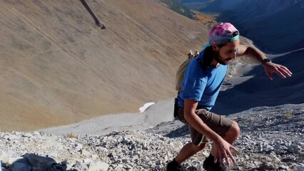 Hiker ascending scrambling climbing close up pan Kananaskis Alberta Canada
