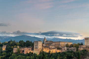 Obraz premium Aerial view of the Alhambra Palace in Granada, Spain with snow-capped Sierra Nevada mountains in the background.