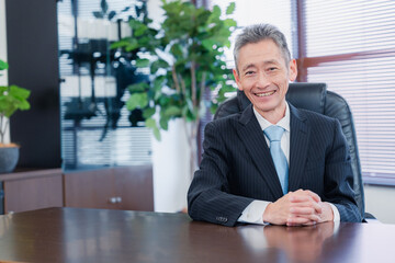 笑顔で椅子に座る経営者の男性