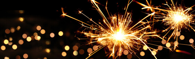 Happy New Year background with glowing sparklers.