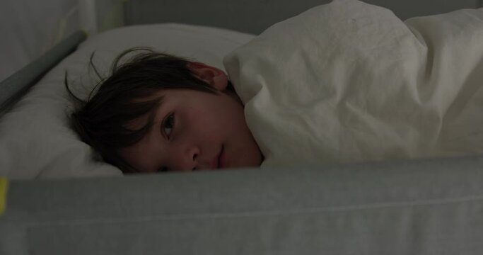 Young boy wakes up in bunk bed  and smiles in morning