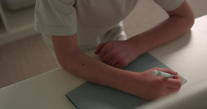 Young Boy Not Sure What To Write On Birthday  Wish List - Close Up On Hands