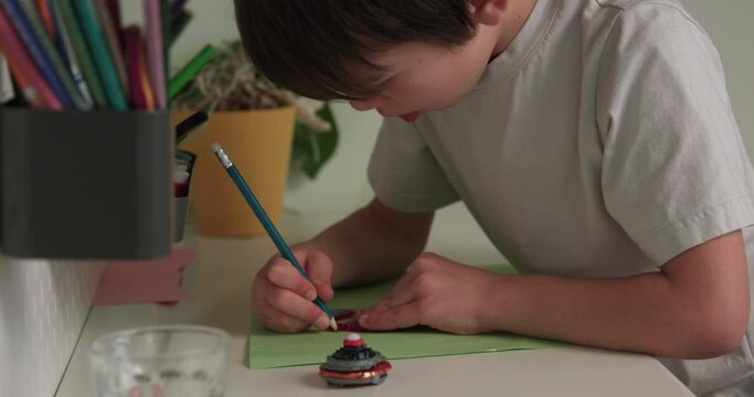 Young boy drawing at desk in bedroom extremely focused - close up