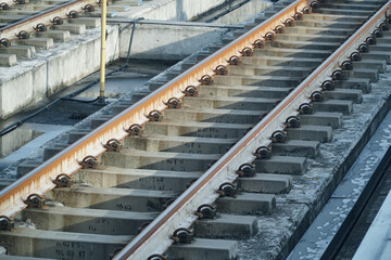 railway tracks in the station. Iron rusty train railway detail over dark stones
