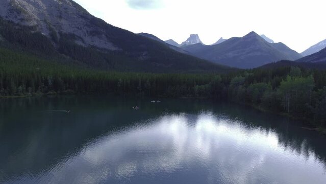 Boats on pond in mountains and forest approached Rockies Kananaskis Alberta Canada