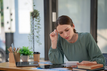 Portrait of a female office worker feeling stressed while working in the office room.