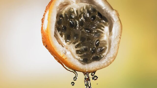 Slow Motion Macro Shot of Flowing Granadilla Juice from Halved Granadilla