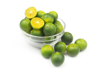 Fresh calamansi lime fruits in glass bowl isolated on white background.	