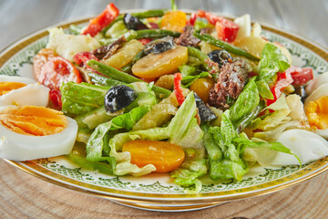 Nicoise salad french cuisine gourmet, on wooden background