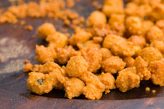 dal pakora or lentil fritters kept on a wooden plate for selling in local shop. very popular deep fried roadside snack in india.
