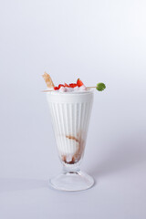 Vanilla milkshake with strawberry garnish white background