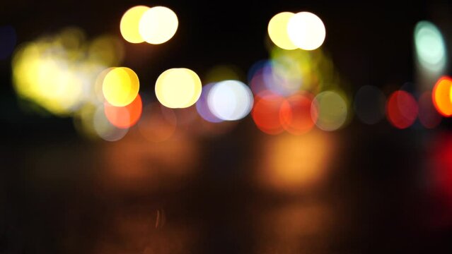 Bokeh car lights in the evening city. Defocused headlights and street lighting at night. Moving bokeh circles of cars at night. Blurred city traffic background