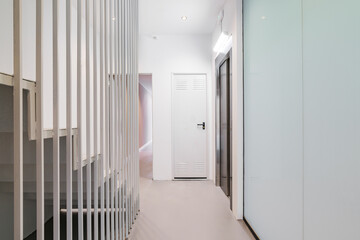 Corridor with passenger lift and stairs leading up. Interior of modern residential building.