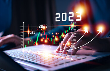 Businessman hand touching and pointing on year 2023 with virtual screen from 2022 to 2023,...