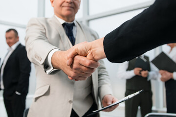 businessman confidently shaking hands with his business partner.