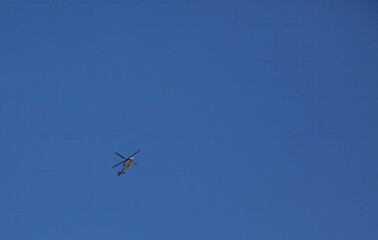 A police helicopter in flight against a blue cloudless sky.