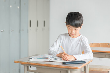 Fototapeta na wymiar 学校の教室で漢字・国語の勉強をする小学生の男女（男子・授業・教育） 