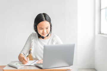 学校の教室・塾でノートパソコンを使って楽しくオンライン学習をする小学生の子供（笑顔・女の子）
