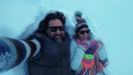 Happy young mature couple enjoy fun leisure activity outdoor playing with the snow in winter holiday vacation. Man and woman together falling inside high soft snow at the park. Overjoyed people fun - Powered by Adobe