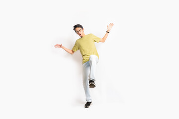 Fototapeta na wymiar A single skinny young male tries to balance his body with one foot. The full body of an Asian or Indonesian person. Isolated photo studio with white background.