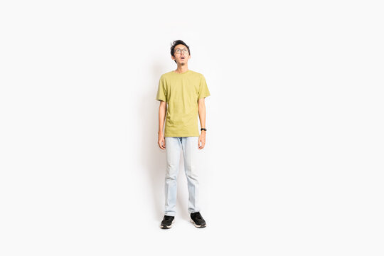 Single skinny young male amazes with mouth wide open. The full body of an Asian or Indonesian person. Isolated photo studio with white background.