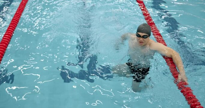 Athlete man training in a swimming pool alone