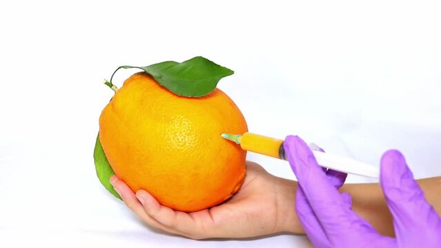 Orange on a white background. Genetically modified foods. Gmo orange. Experiments with food. injections into fruits. fight against cellulite