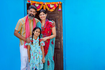 Fototapeta na wymiar Happy indian farmer couple with daughter at home.