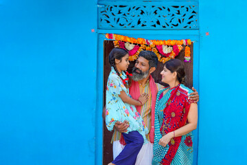 Happy indian farmer couple with daughter at home.