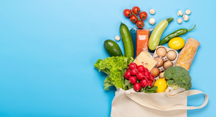 Shopping bag full of healthy food on blue