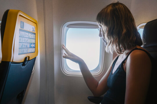 Woman Looking Through Airplane Window