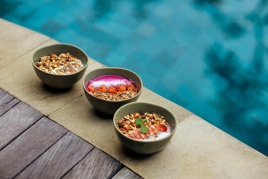 Three ready to eat bowls of strawberry, peanut butter and pitaya muesli