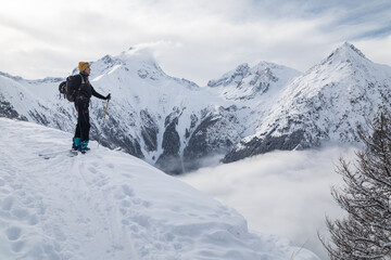 Fototapeta na wymiar Woman doing ski touring in front of scenic view in mountains