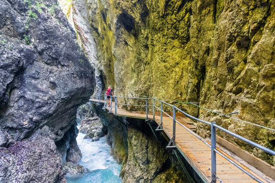 Austria, Boardwalk stretching through Leutasch Gorge with female hiker standing in background