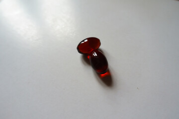 Close view of two red softgel capsules of krill oil