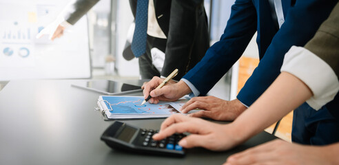 Business team on office table with smart phone and calculator digital tablet and graph business with social network diagram and two colleagues discussing data working in the office