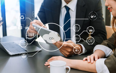Business team working virtual modern smartphone to reduce CO2 emissions carbon footprint climate change to limit global warming.Sustainable development and green business concept. .