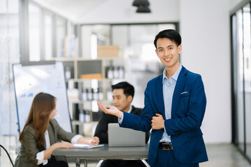 Confident business expert attractive smiling young man holding digital tablet  on desk in creative office..