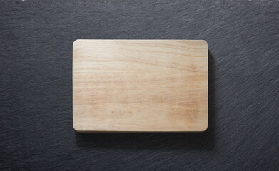 Wooden cutting board against a slate plate