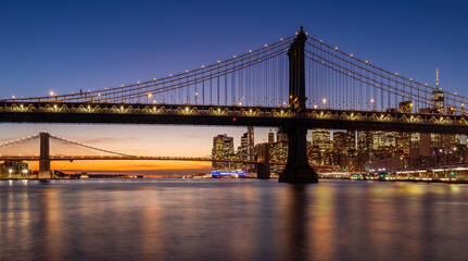 Fototapeta na wymiar Manhattan Bridge and Brooklyn Bridge with East River just after sunset. Lower Manhattan skyline at dusk, New York City