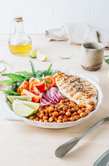 Spicy Chicken Nourish Bowl. A filling and nutritious warm salad with grilled chicken, spicy chickpeas, tomato and arugula