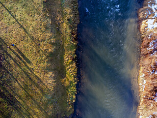Aerial view. Flowing river, nature, winter, snow, meadow.